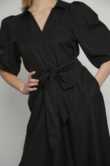 Fototapeta premium Serie of studio photos of young female model in black viscose midi dress