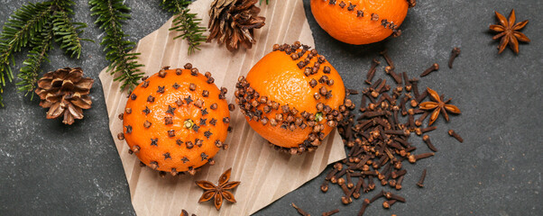 Pomander balls and clove spice on grey background, top view