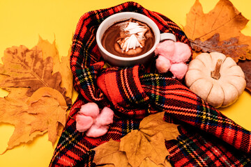 Autumn composition of a cup of coffee with marshmallow on a yellow background