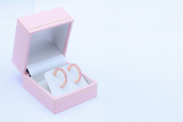 Pink sapphire earring in pink jewelry box on white background. Precious gift or present for special...