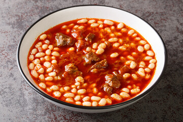 Turkish white bean stew with meat Etli kuru fasulye closeup in the plate on the table. Horizontal