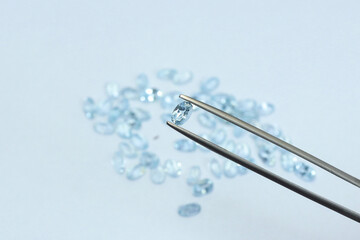 Blue aquamarine or blue topaz gemstone with light blue color on silver tray