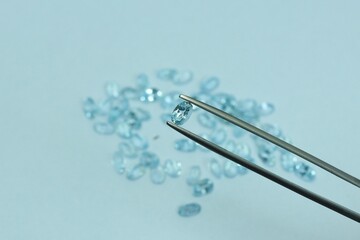 Blue aquamarine or blue topaz gemstone with light blue color on silver tray