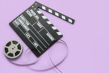 Movie clapper with reel on lilac background