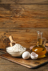 Different ingredients for baking against wooden background