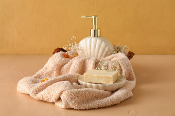 Composition with soap, towel and gypsophila flowers on color background