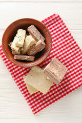 Bowl of sweet sesame halva on light wooden background