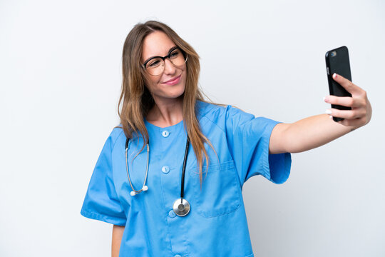 Young surgeon doctor woman isolated on blue background making a selfie