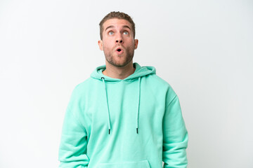 Young handsome caucasian man isolated on white background looking up and with surprised expression