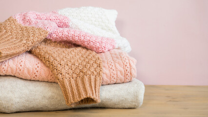 Stack of knitted things in beige and pink colors