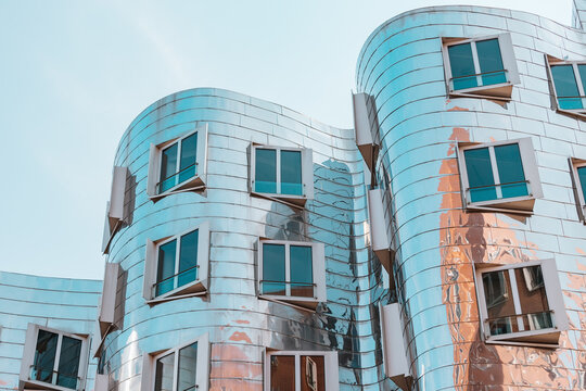 23 July 2022, Dusseldorf, Germany: Detail of Gehry Bauten or Zollhof unusual modern architecture buildings sheathed with metal in Media Harbor. Dancing houses and travel attractions