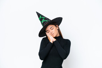 Young caucasian woman costume as witch isolated on white background making sleep gesture in dorable expression