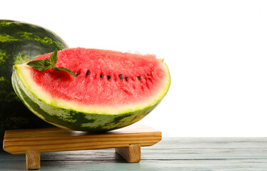 Stand with cut watermelon and mint on table against white background