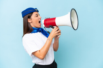 Airplane stewardess caucasian woman isolated on blue background shouting through a megaphone