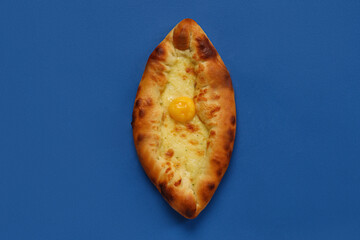 Tasty Ajarian khachapuri on blue background