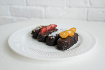 Delicious pastries with chocolate icing and berries on the table.
