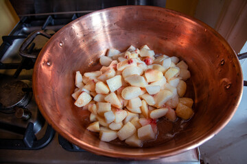 slowly cooking fruits in a copper pot