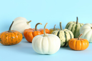 Different pumpkins for Halloween party on color background