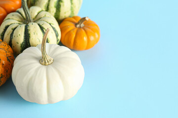 Different pumpkins for Halloween party on color background