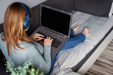 Cropped shot of young businesswoman working on a laptop computer in office at her home. Working at home concept. Mockup image of a woman pointing finger at a computer with blank white screen