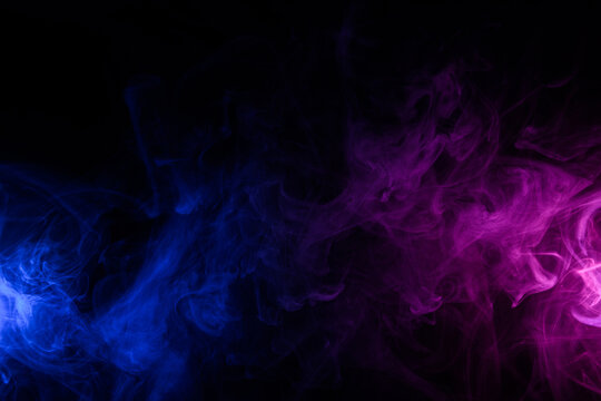 Flowing clouds of colorful swirling blue and purple neon smoke dark abstract background
