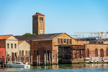 Fototapeta na wymiar Murano island, bell tower of the Cathedral, Basilica of saints Maria and Donato, VII century, and abandoned ancient glass factories. Venice lagoon, UNESCO world heritage site, Veneto, Italy, Europe.