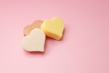 Heart shaped pink bar of soap on a light pink background. Top view, copy space. Heart shaped soaps. Importance of personal hygiene care. Copy space.