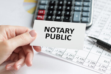 a woman in a white shirt holds a piece of paper with the text: notary public. business concept for companies