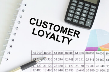 Customer Loyalty text written on a notebook with pencils.