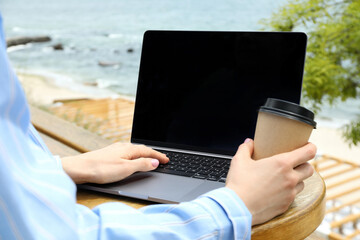 Young woman working on laptop outdoor, concept of freelancer