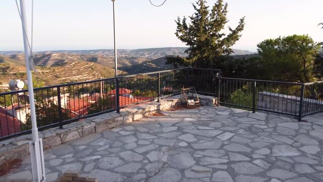 Aerial sunset drone footage of traditional countryside hilltop village Vouni, Limassol, Cyprus. EOKA monument close up to christian church Ioannis Prodromos, ceramic tiled roof architecture from above
