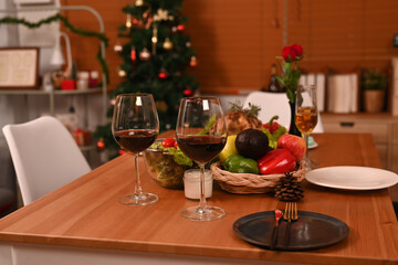 Thanksgiving table or Christmas dinner with glasses of red wine, roasted turkey and all sides dishes in decorated room