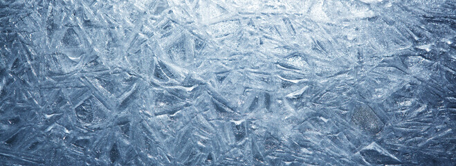 The texture of the ice surface. Winter background, festive background in the form of ice crystals, in natural deep blue color.