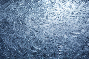 The texture of the ice surface. Winter background, festive background in the form of ice crystals, in natural deep blue color.