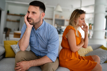 Fototapeta na wymiar Sad pensive couple thinking of relationships problems sitting on sofa, conflicts in marriage.