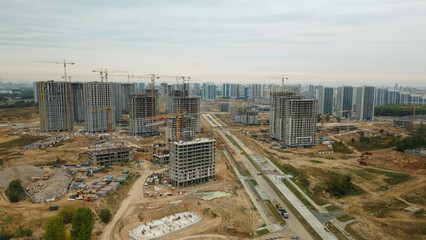 Construction site of a new city block. Construction of multi-storey buildings. Overcast weather. Aerial photography.