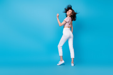 Full length photo of pretty adorable millenial lady dance enjoy rejoice cool weekend vacation empty space isolated on blue background