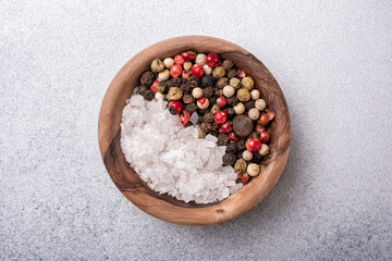 Different pepper spice ans sea salt in wooden bowl for tasty meals