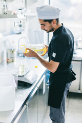 Italian chef pizzaiolo preparing pizza dough in restaurant kitchen