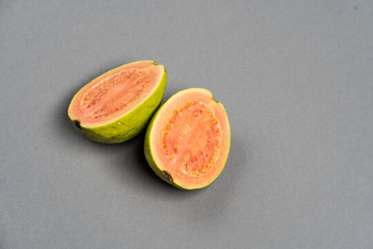 The common guava Psidium guajava (lemon guava, apple guava) on grey color background. Close up view.