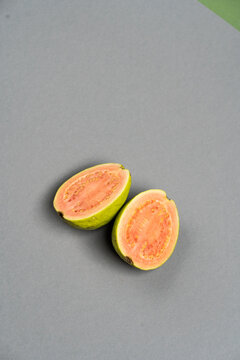 The common guava Psidium guajava (lemon guava, apple guava) on grey color background. Close up view.