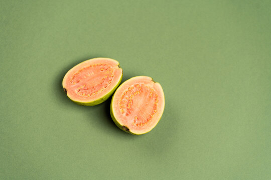 The common guava Psidium guajava (lemon guava, apple guava) on green olive color background. Close up view.