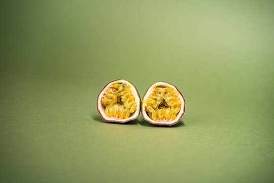 The passion fruit is the fruit of a number of plants in the genus Passiflora on green olive color background. Close up view.