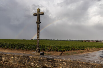 Fototapeta na wymiar rainbow behind the romanee conti cross in vosne romanee