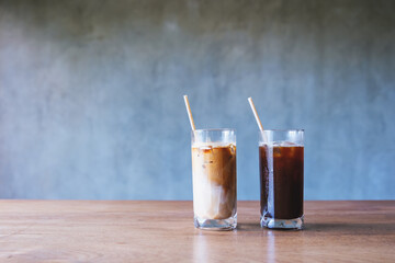 Two glasses of iced coffee with bio drinking straws on wooden table