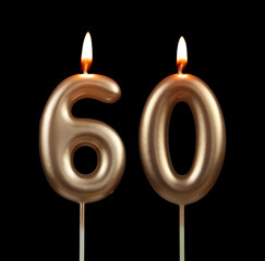 Melting golden birthday candles isolated on black background, number 60