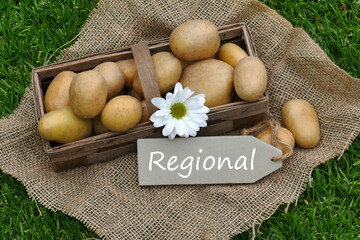 A basket of potatoes with the text regional on a sign. - obrazy, fototapety, plakaty