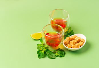 Tea time. Tea in a double wall glasses garnished with mint, cane sugar and lime.