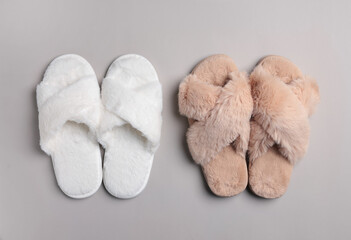 Different soft fluffy slippers on light grey background, flat lay