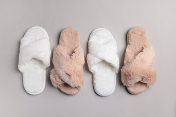 Fototapeta na wymiar Different soft fluffy slippers on light grey background, flat lay